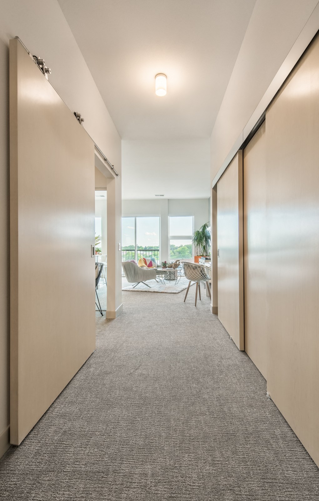 a room with a carpeted floor and rows of closet doors