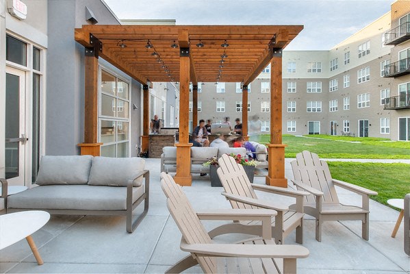 an outdoor patio with chairs and a wooden canopy
