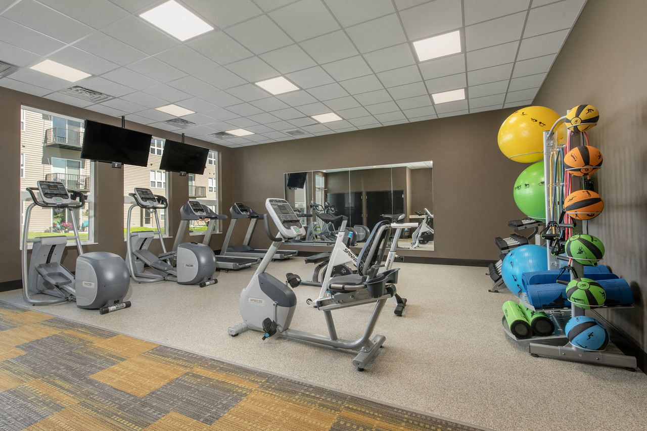 a gym with cardio equipment and weights in a building