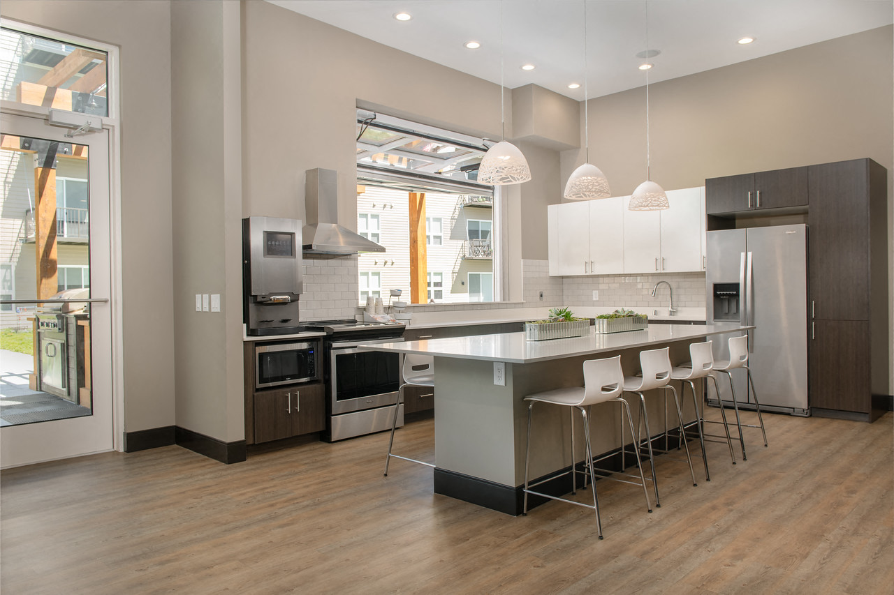 a kitchen with a large island and stainless steel appliances