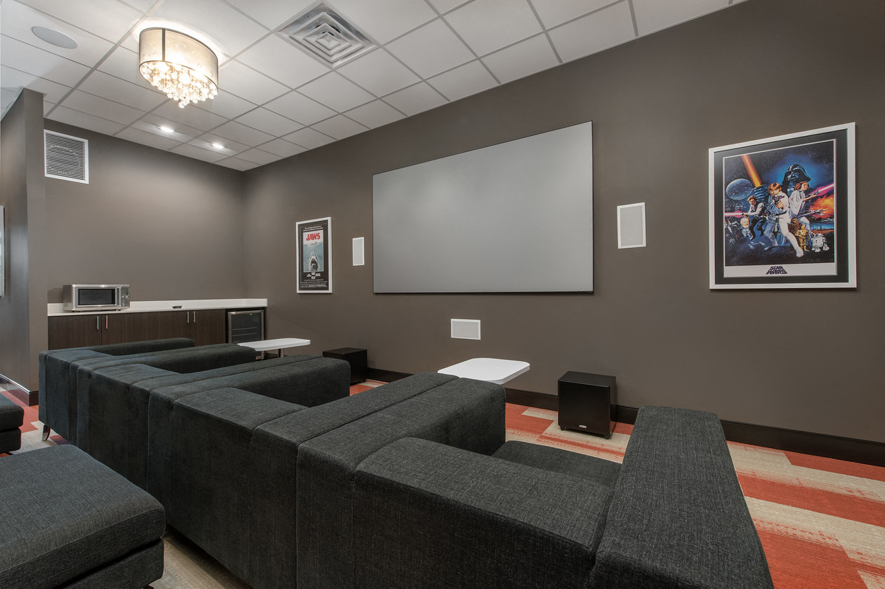 a screening room with couches and a screen on the wall