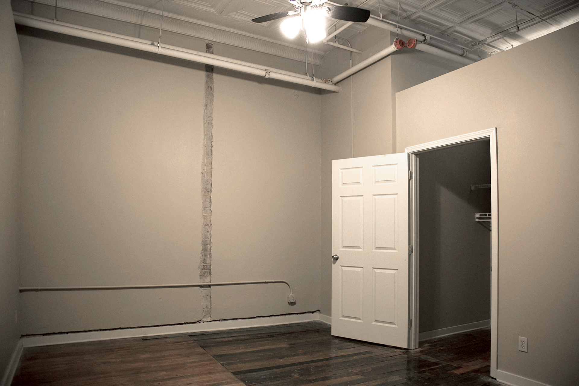 Large bedroom with ceiling fan and hardwood floors  at Fix Play Lofts, Birmingham, AL