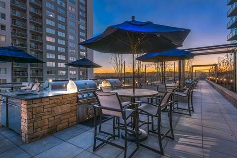 a patio with tables and umbrellas at dusk