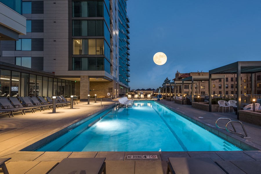 a swimming pool at night with a full moon