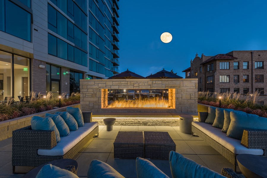 a lounge area with a fire pit at night