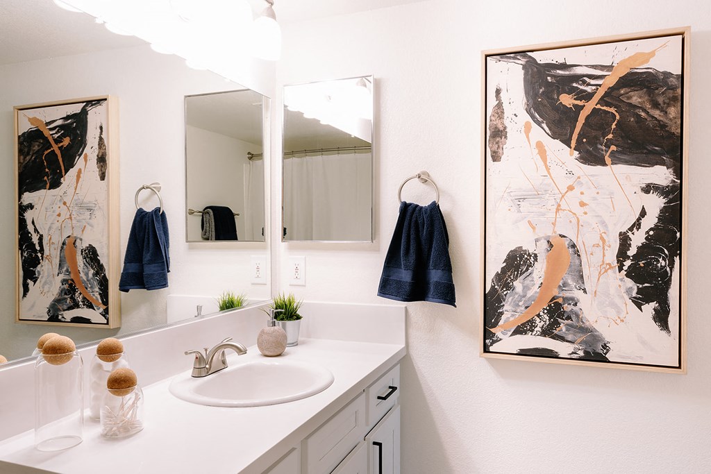 a bathroom with two mirrors and a sink and a mirror on the wall