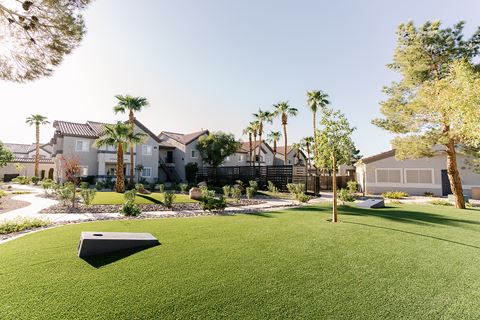 a yard with artificial turf and houses in the background