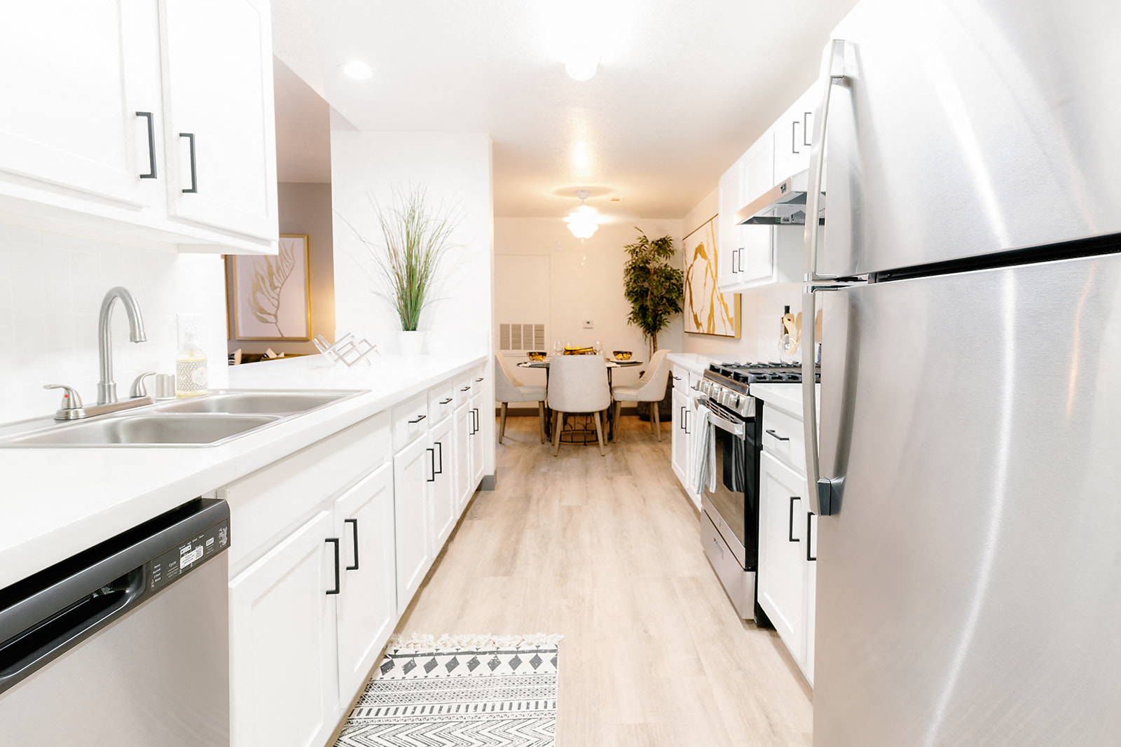 a large kitchen with white cabinets and stainless steel appliances
