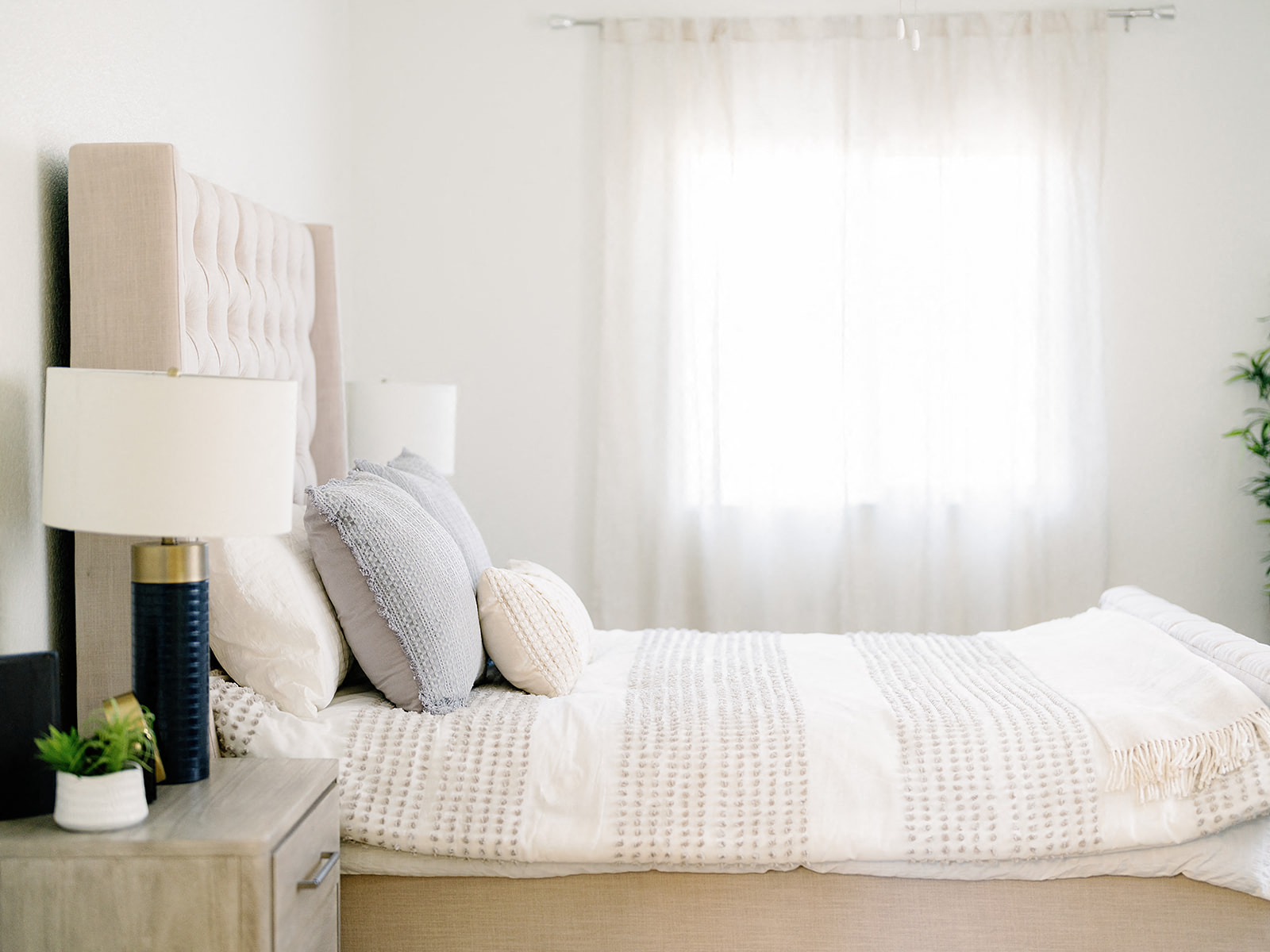 a bedroom with a bed with white sheets and pillows