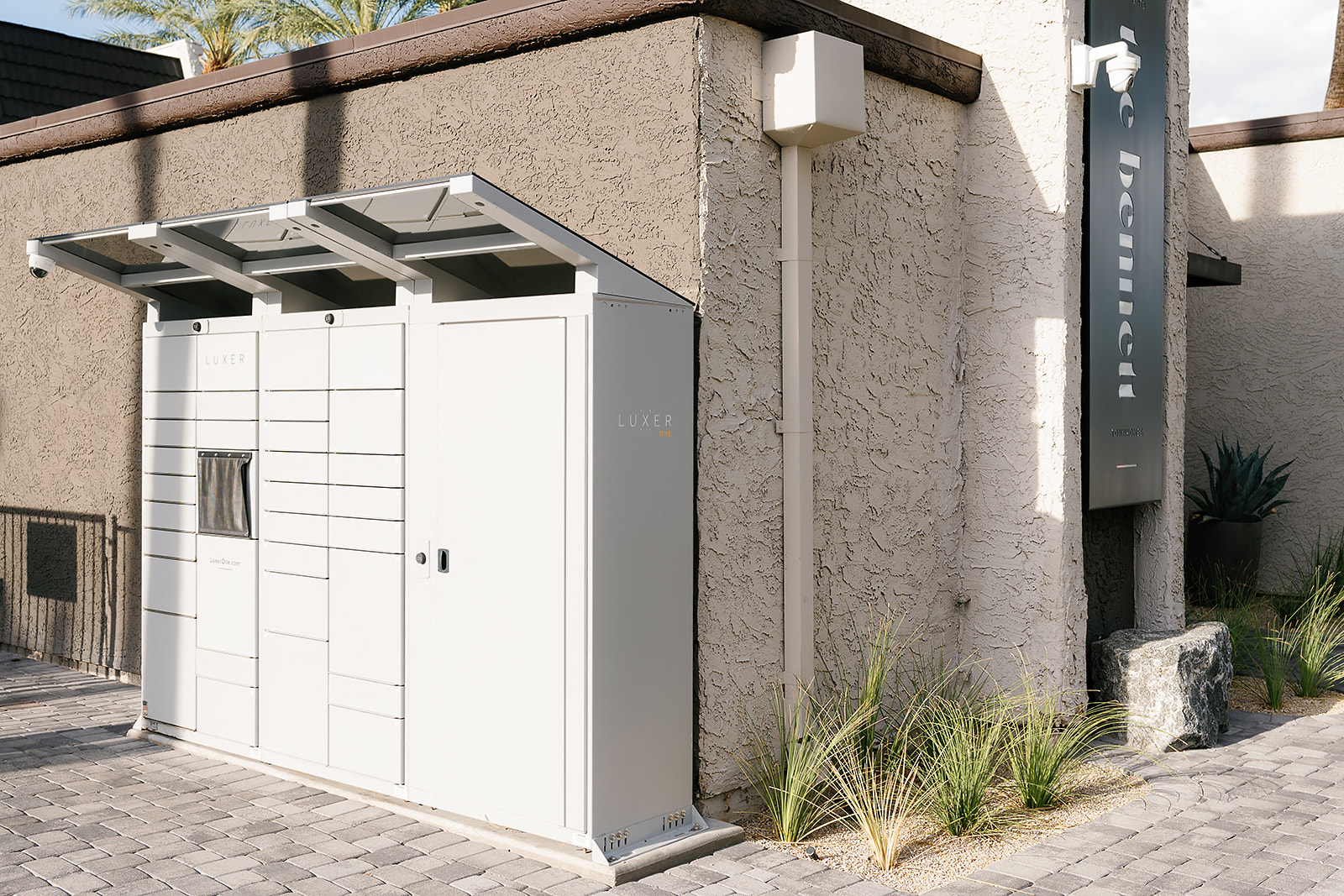 a small white outhouse in front of a building