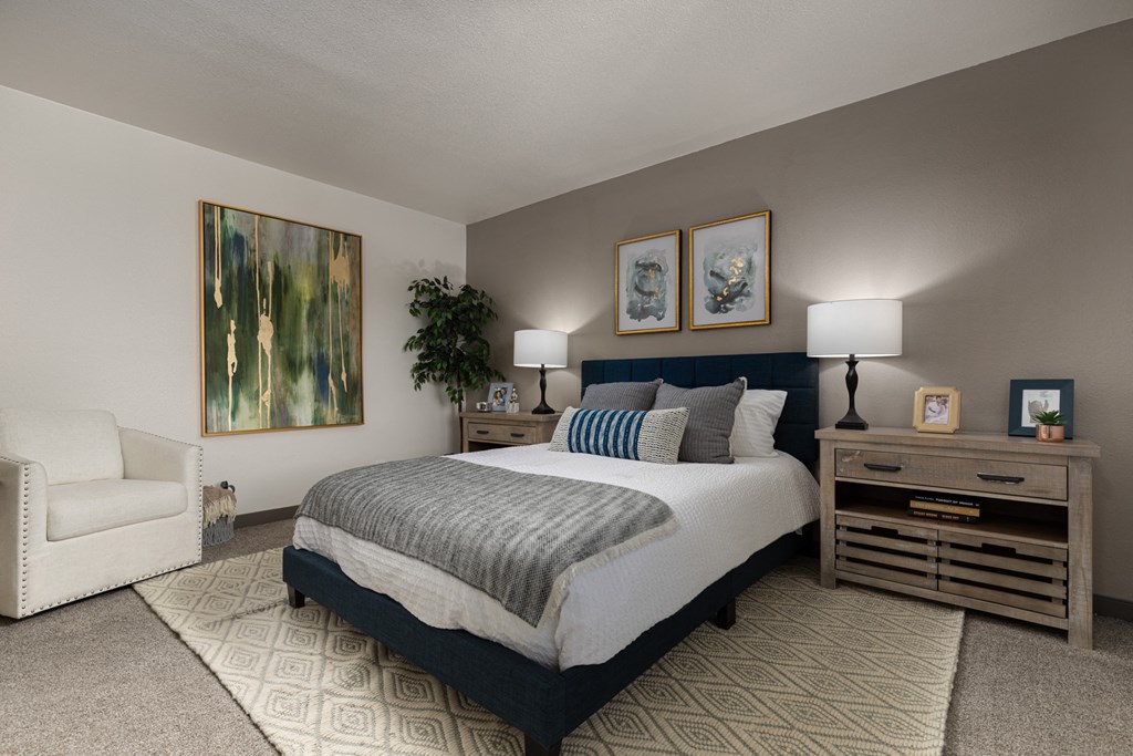 a bedroom with a bed and a chair and a dresser