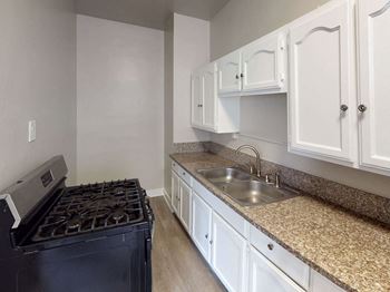 Kitchen With White Cabinetry, Marble Detailing, and Stainless Steel Appliances at Hobart Apartments, California, 90029