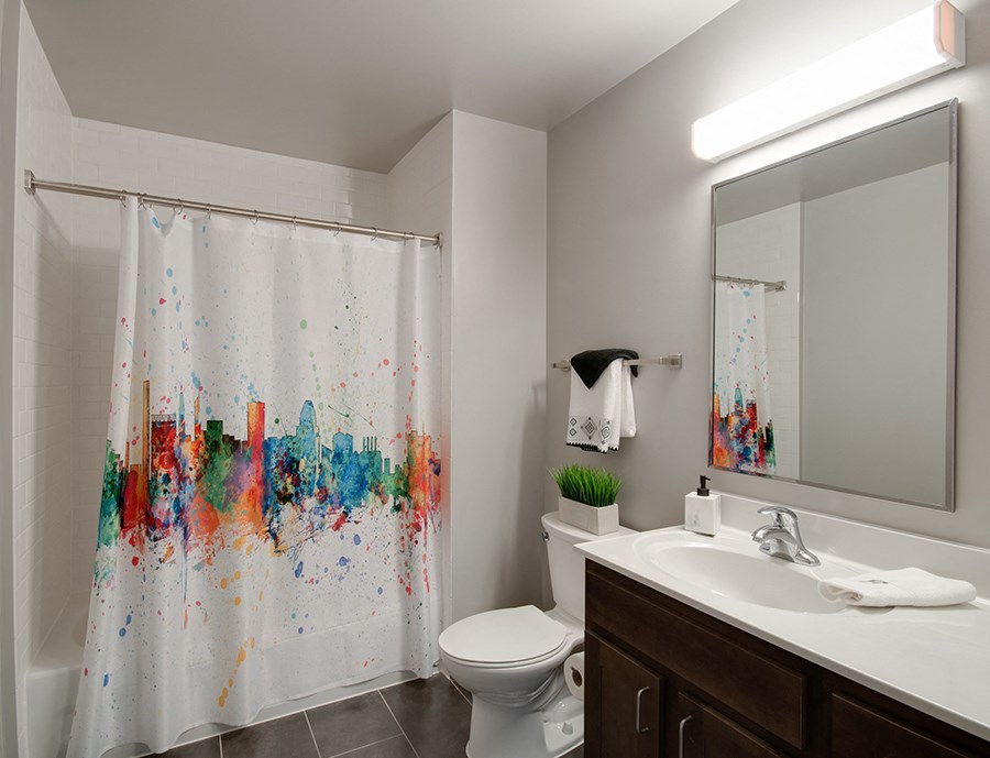 a bathroom with a toilet sink and shower and a mirror