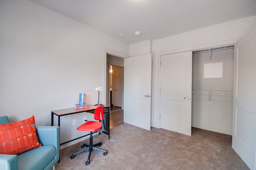 a room with a desk and a chair and a closet