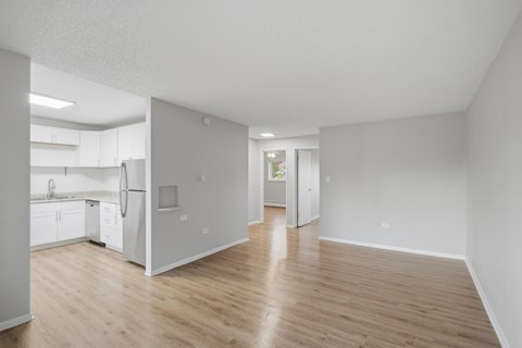 A kitchen with white appliances and wooden floors.