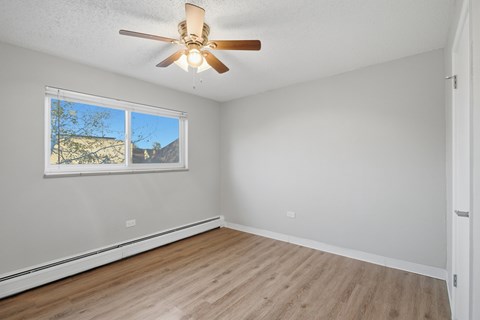 A room with a ceiling fan and a window.