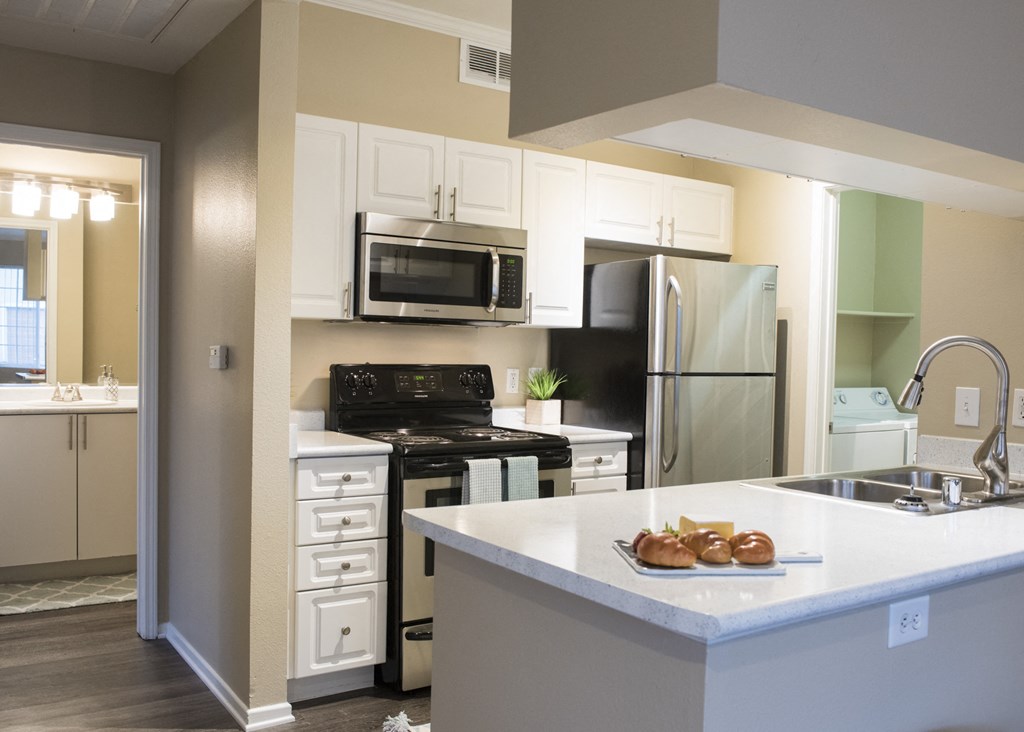 a kitchen with white cabinets and stainless steel appliances