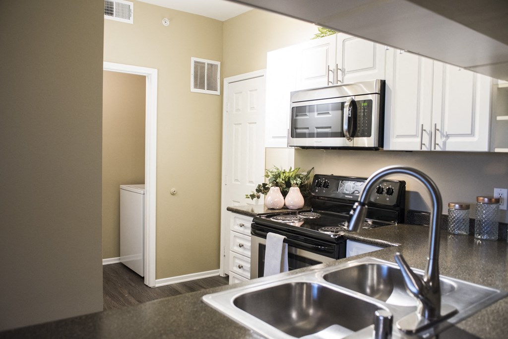 a kitchen with a sink and a stove and a microwave