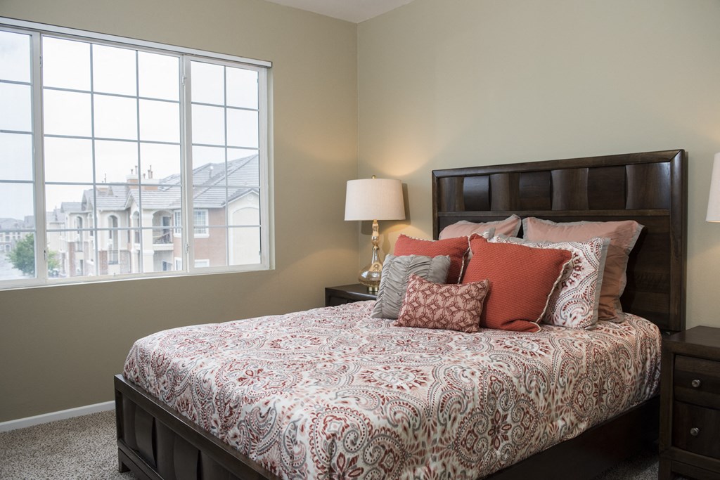 a bedroom with a bed and a large window