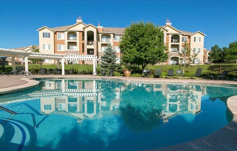 a large swimming pool with an apartment building in the background