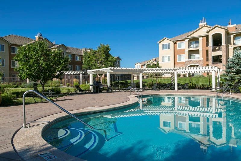 a swimming pool with an apartment building in the background