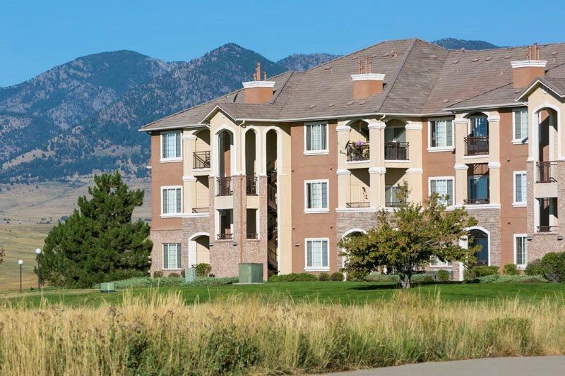 a large apartment building with a mountain in the background