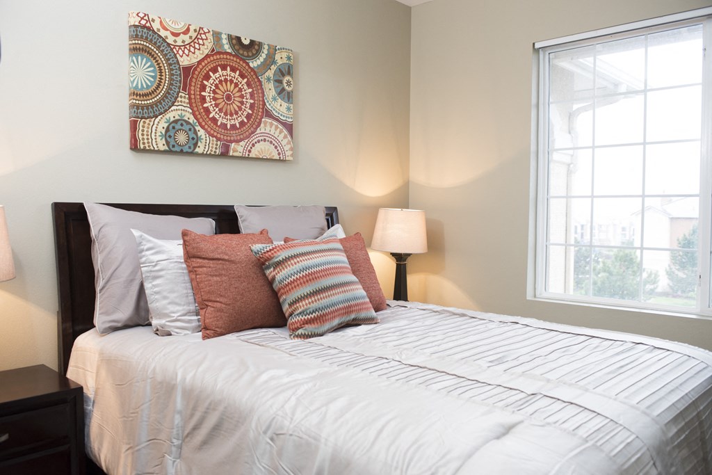 a bedroom with a bed and a painting on the wall