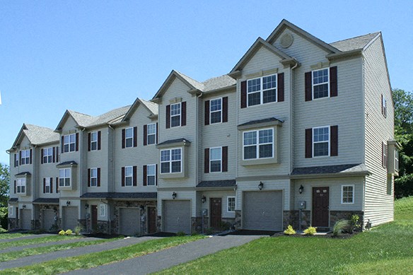 a row of houses with garage doors and a sidewalk