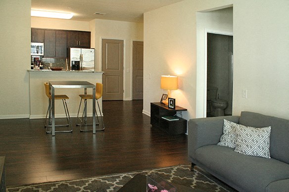 a living room with a couch and a kitchen with a bar