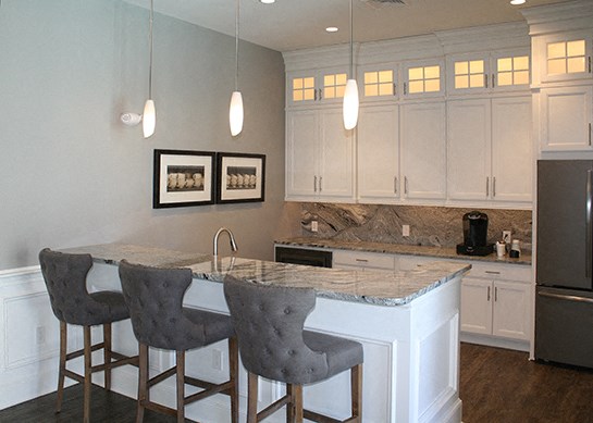 a kitchen with a marble counter top and three stools