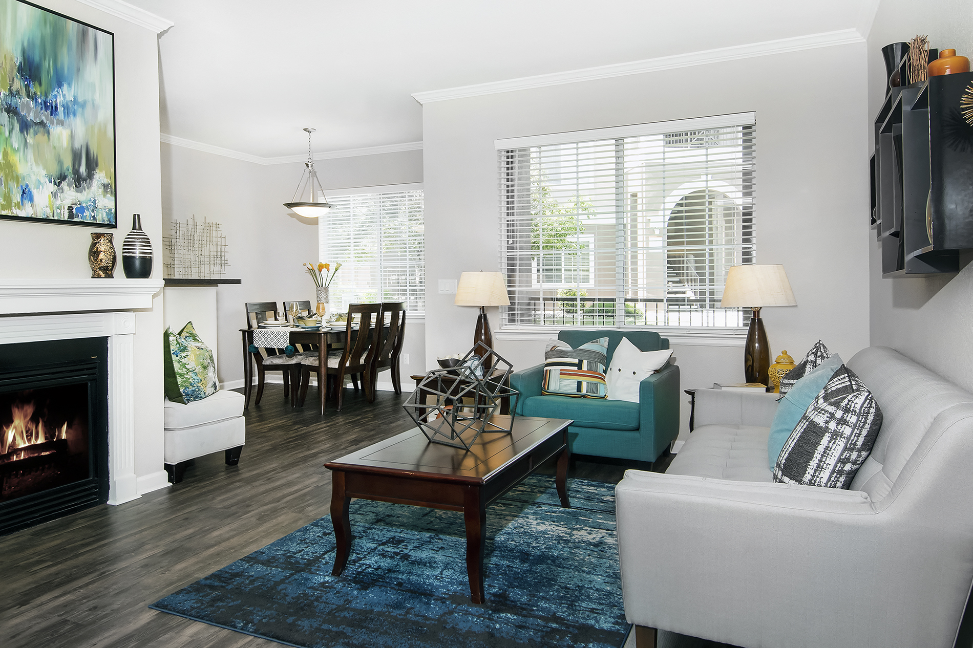A living room with a fireplace and a blue rug.