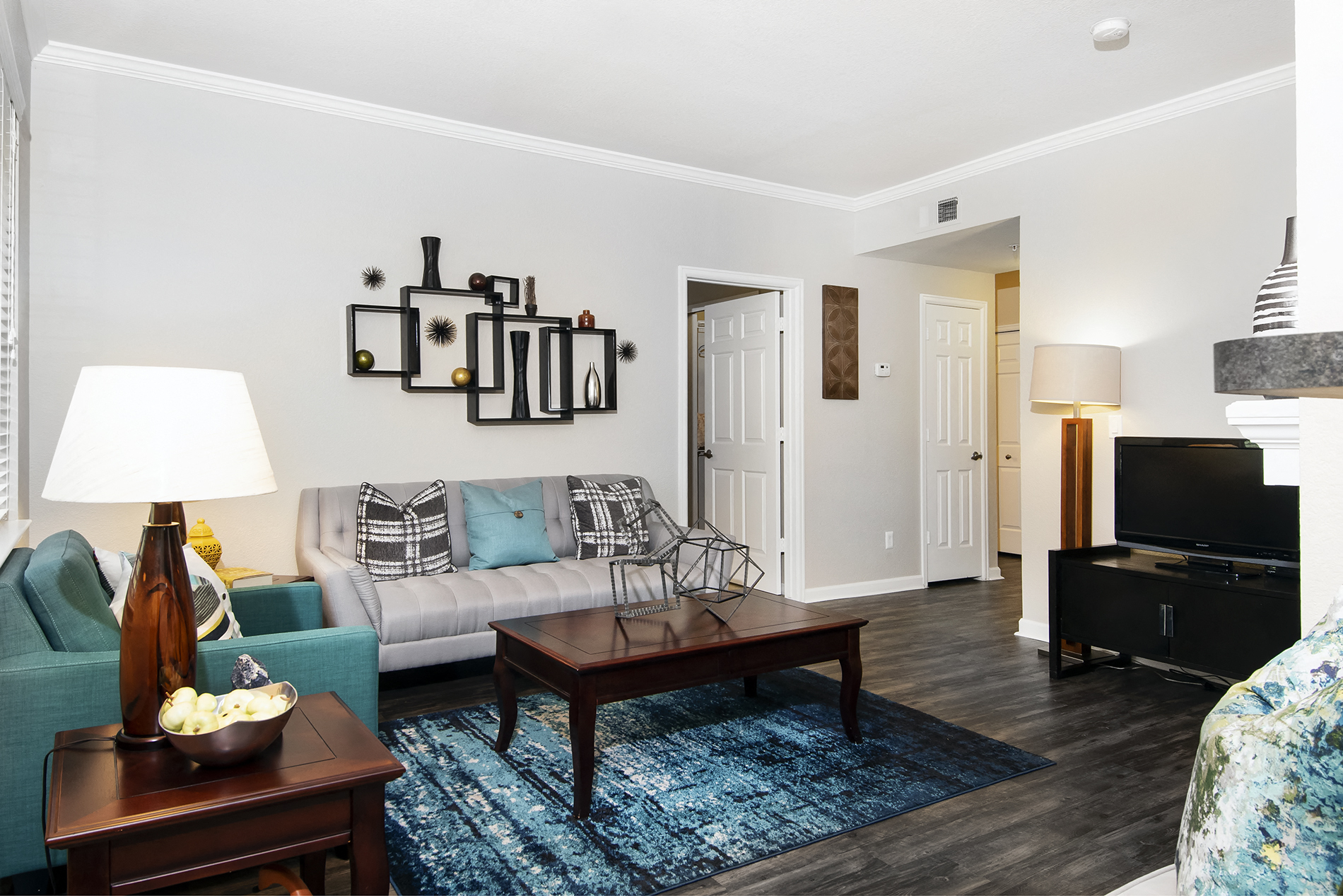 A living room with a blue rug and a wooden coffee table.