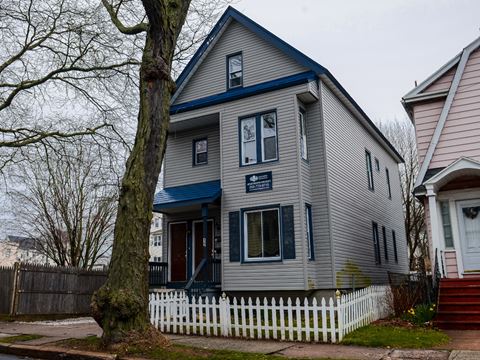 a house with a blue roof and a white picket fence