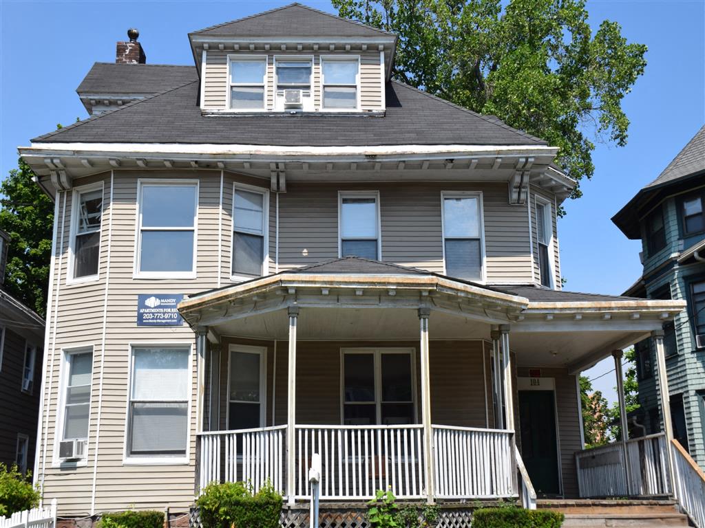 A two-story house with a balcony on the second floor.