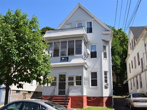 A white two-story house with a red staircase.
