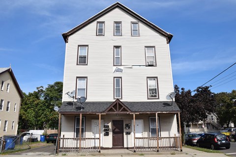 A two-story white house with a brown door and windows.