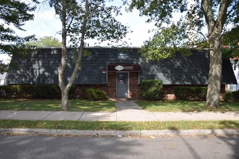 A building with a red door and a sign that says "HANDY" on it.
