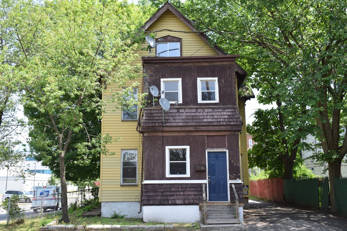 A two-story house with a blue door and windows.