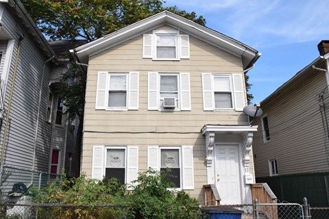 A two-story house with a white door and windows.