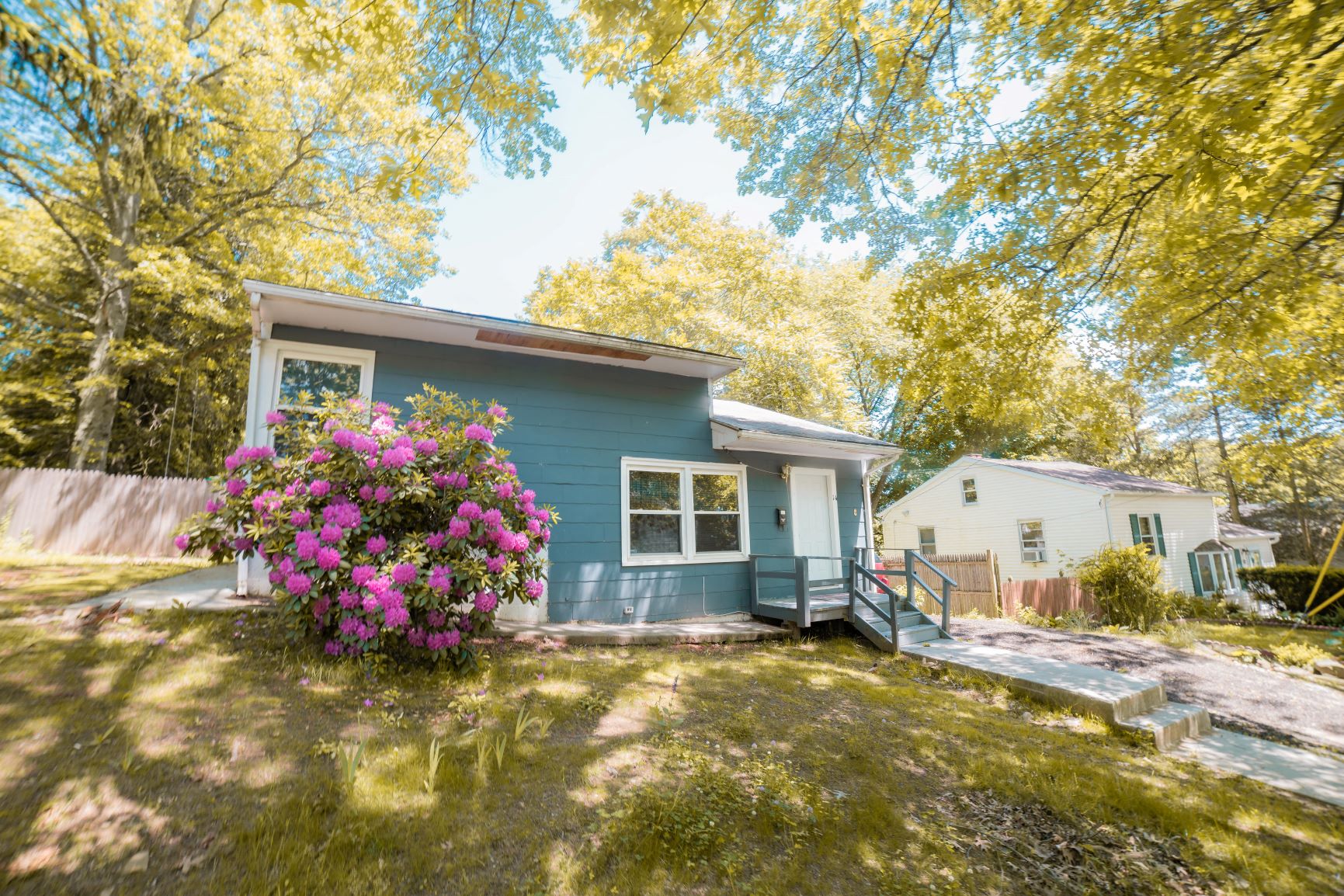 A blue house with a flower pot in front of it.