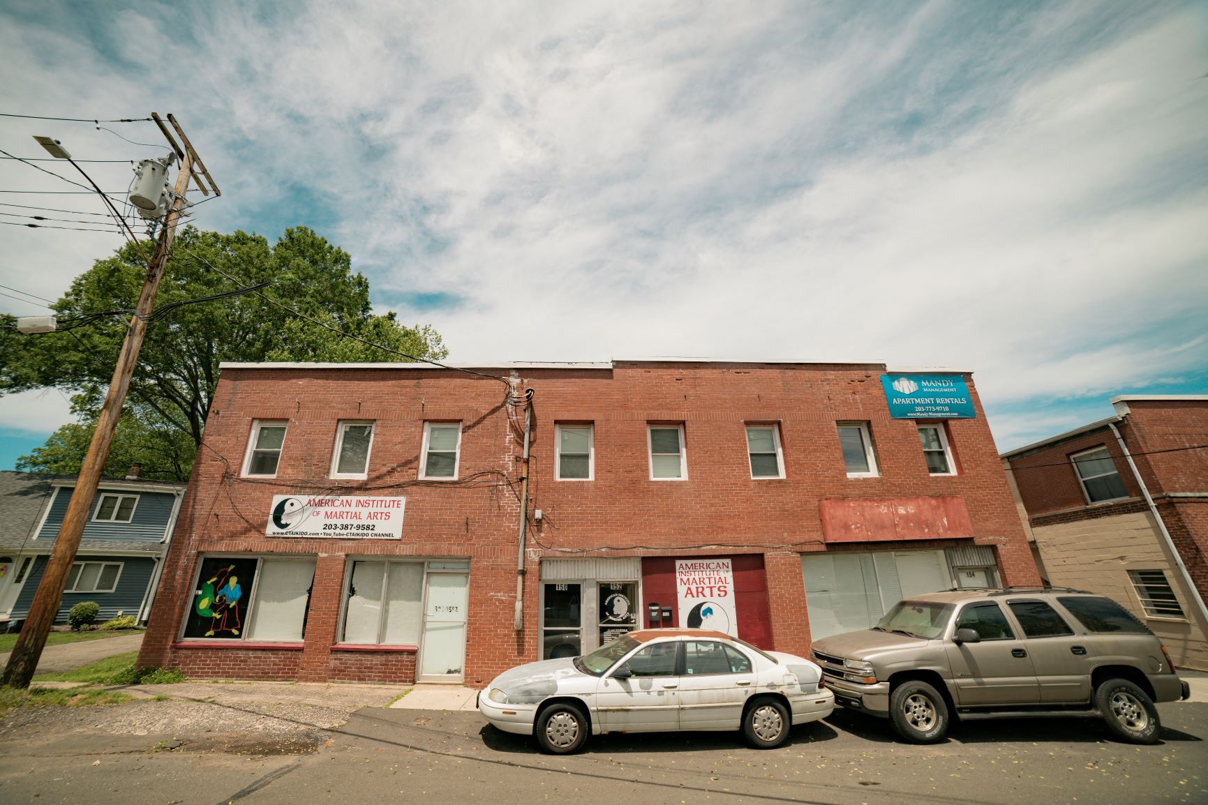 A car is parked in front of a building with a sign that says "Artisan Crafts".