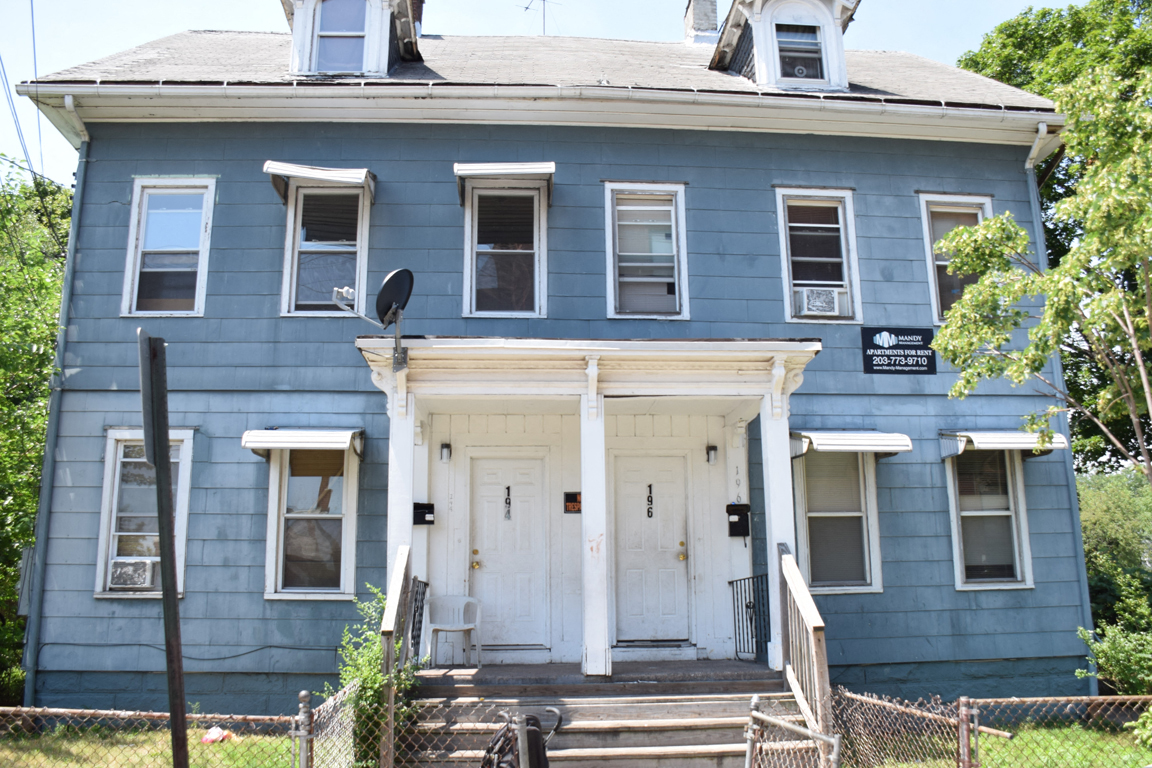 A blue house with a white door and windows.