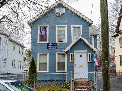 A blue house with a white door and windows.