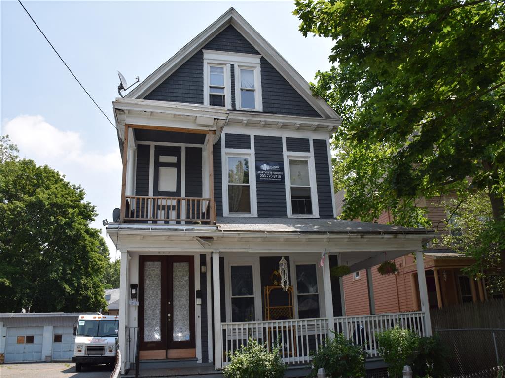 A two-story house with a balcony and a porch.