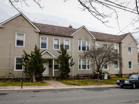 A two-story house with a grey siding and a red roof.