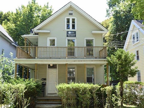 A two-story house with a balcony on the second floor.