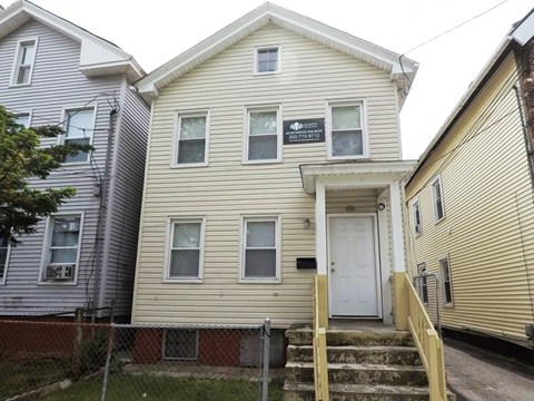A two-story house with a white door and a small porch.