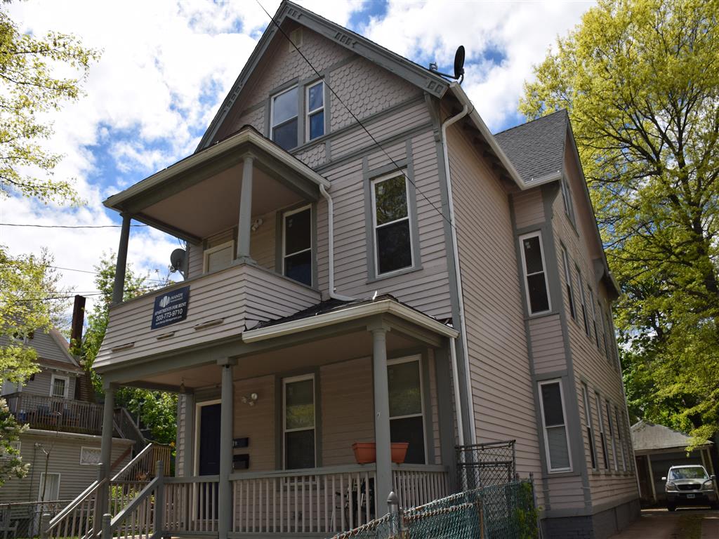 A two-story house with a balcony and a porch.