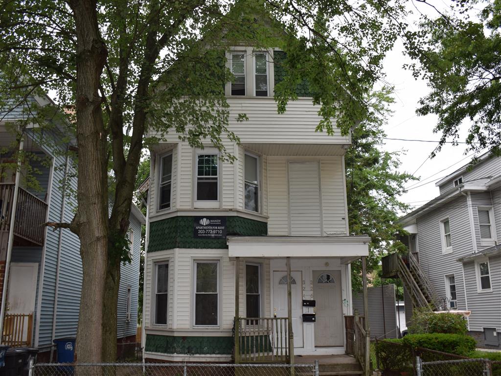 A two story house with a green trim.