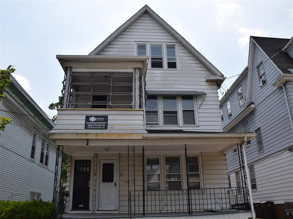 A two-story house with a balcony on the second floor.
